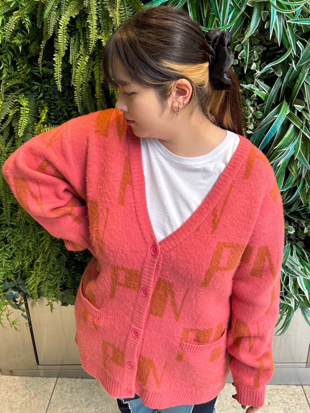 ピンク系のカーディガン/ボレロ、ブルー系のデニムパンツを着用したレディースの冬コーディネートの2枚目の写真