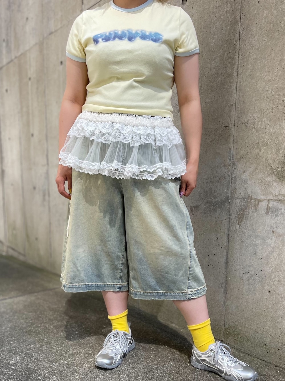 ブルー系のデニムパンツ、ホワイト系のスカート、イエロー系のTシャツ/カットソーを着用したレディースの夏コーディネートの7枚目の写真
