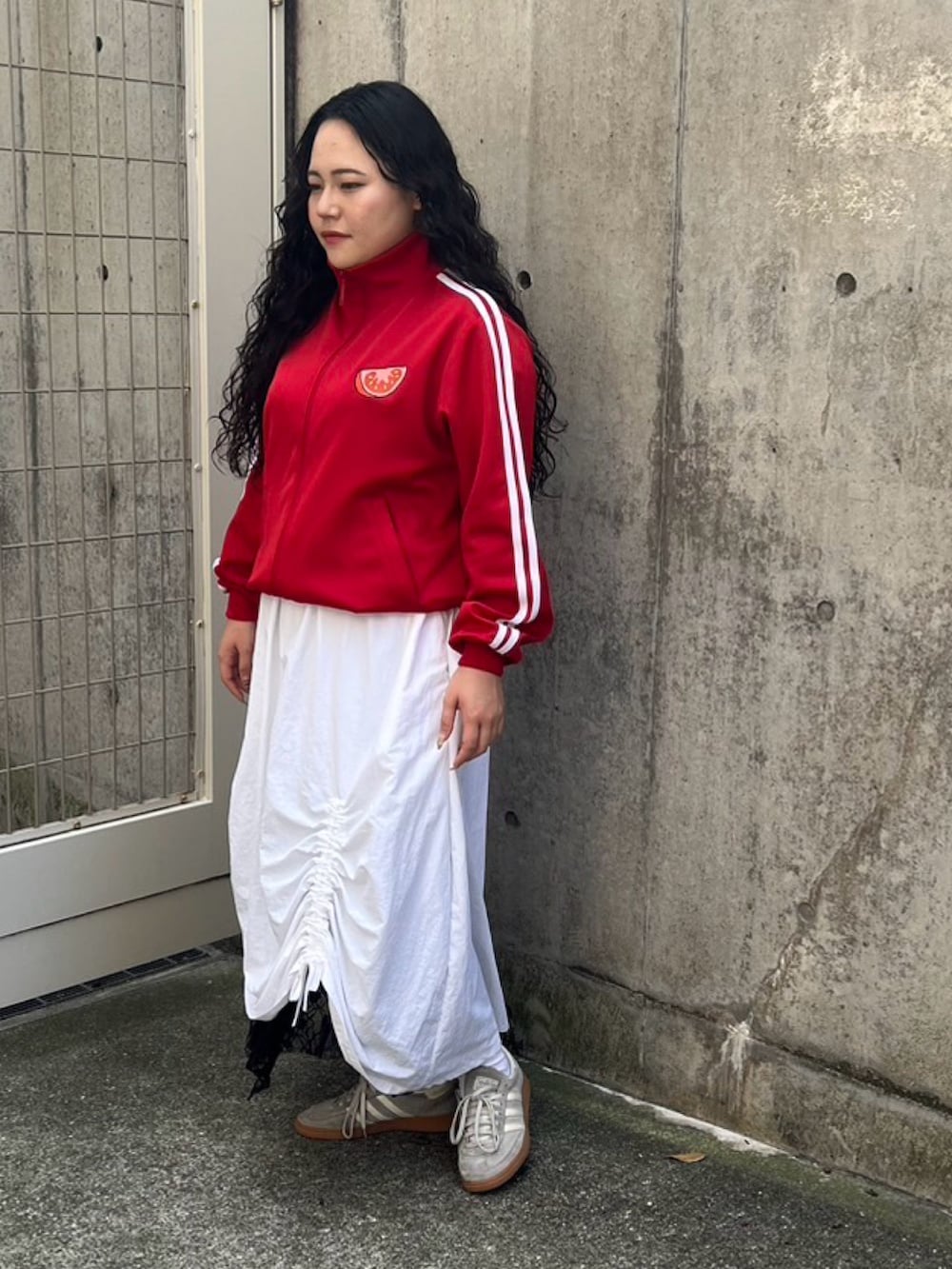 ホワイト系のスカート、レッド系のジャージを着用したレディースの秋コーディネートの3枚目の写真