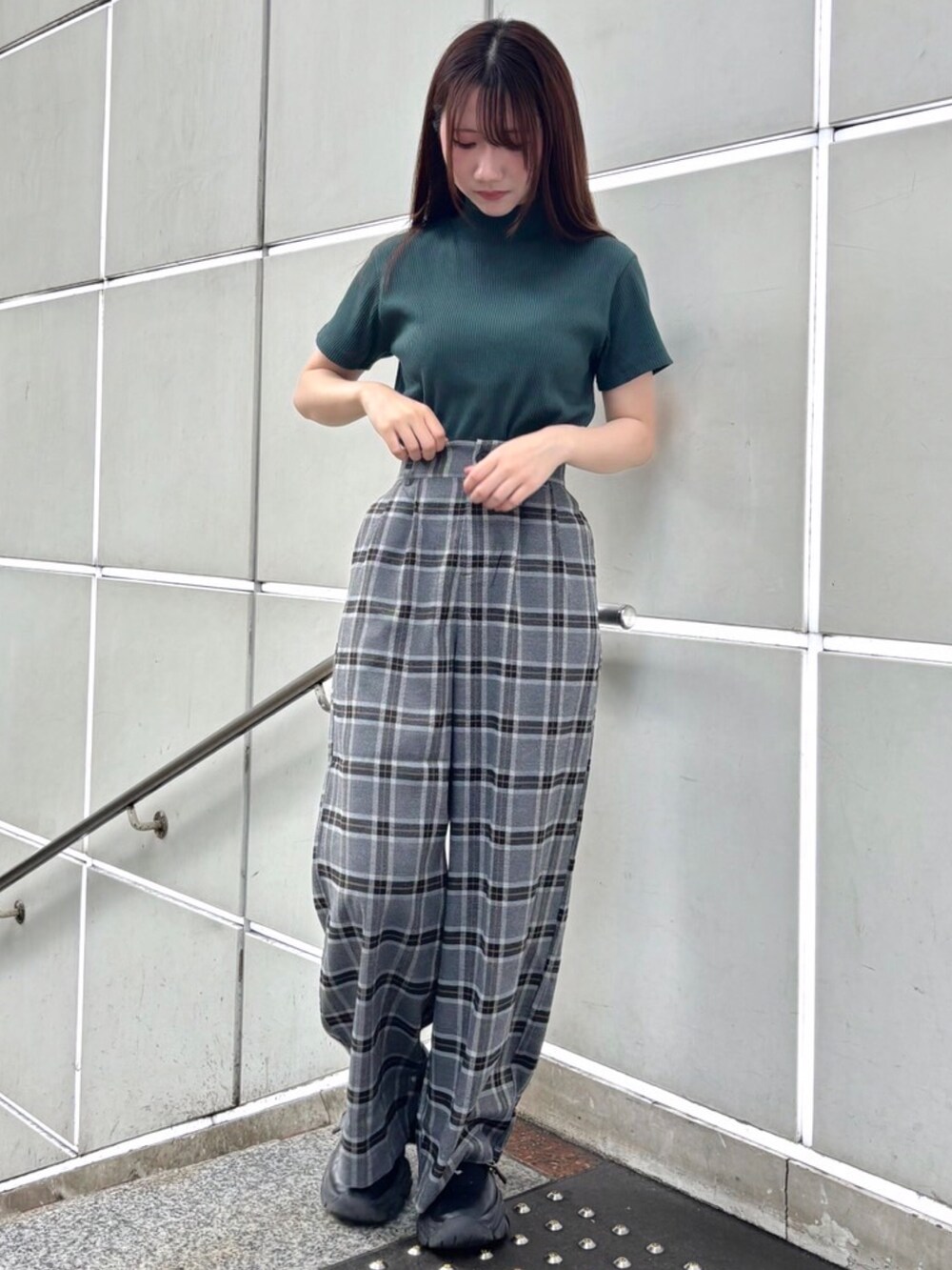 グレー系のスラックス、グレー系のテーラードジャケット、グリーン系のTシャツ/カットソーを着用したレディースの秋コーディネートの2枚目の写真