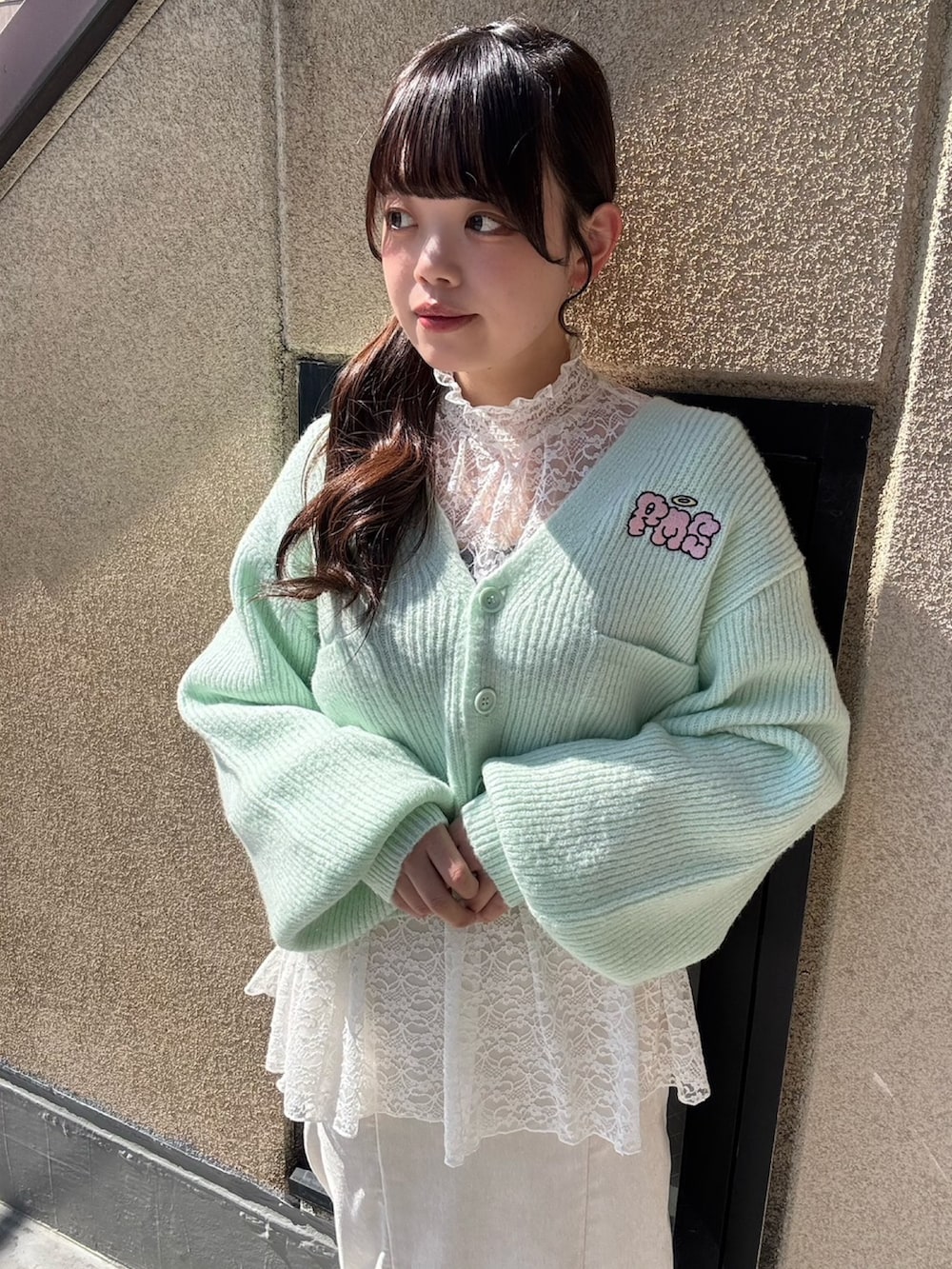 ホワイト系のスカート、ホワイト系のTシャツ/カットソー、グリーン系のカーディガン/ボレロを着用したレディースの春コーディネートの4枚目の写真