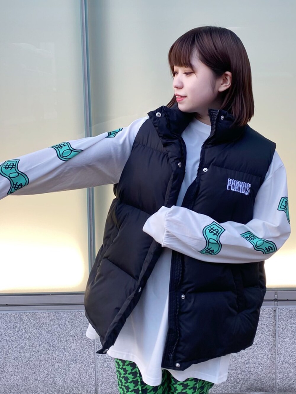 グリーン系のその他パンツ、ブラック系のダウンベスト、ホワイト系のTシャツ/カットソーを着用したレディースの冬コーディネートの2枚目の写真