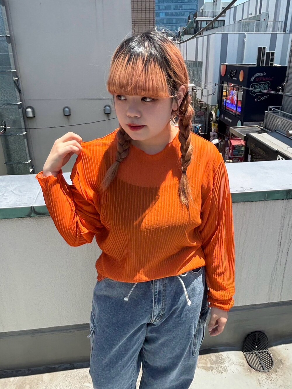 ブルー系のデニムパンツ、オレンジ系のTシャツ/カットソーを着用したレディースの夏コーディネートの2枚目の写真