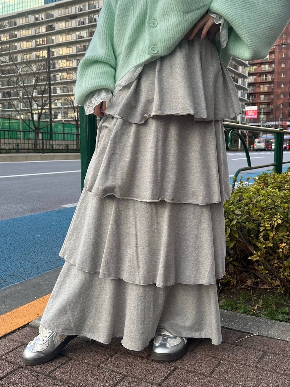 グレー系のスカート、グリーン系のカーディガン/ボレロ、ホワイト系のTシャツ/カットソーを着用したレディースの冬コーディネートの3枚目の写真