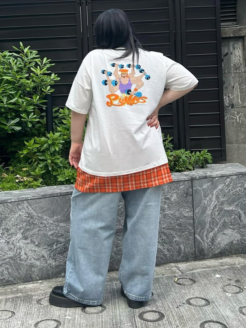 ブルー系のデニムパンツ、オレンジ系のスカート、ホワイト系のTシャツ/カットソーを着用したレディースの春コーディネートの4枚目の写真