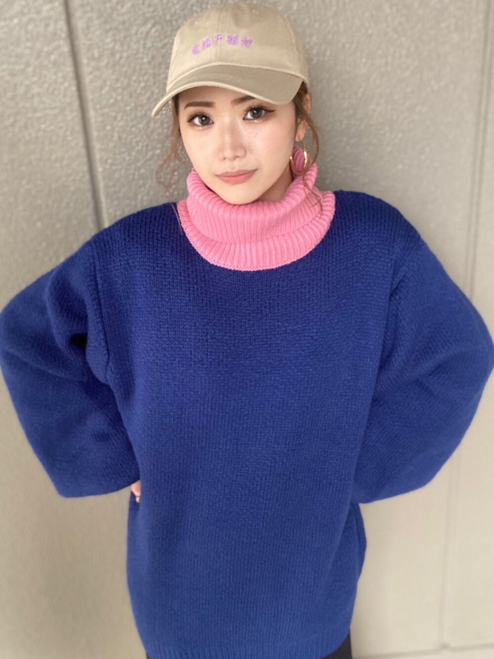 ブルー系のニット/セーター、ブラック系のスカート、ベージュ系のキャップを着用したレディースの冬コーディネートの2枚目の写真