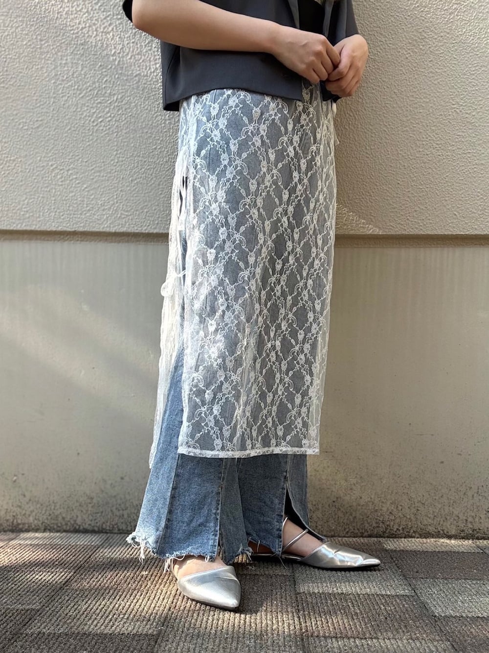 ホワイト系のスカート、ブルー系のデニムパンツ、グレー系のテーラードジャケットを着用したレディースの夏コーディネートの3枚目の写真