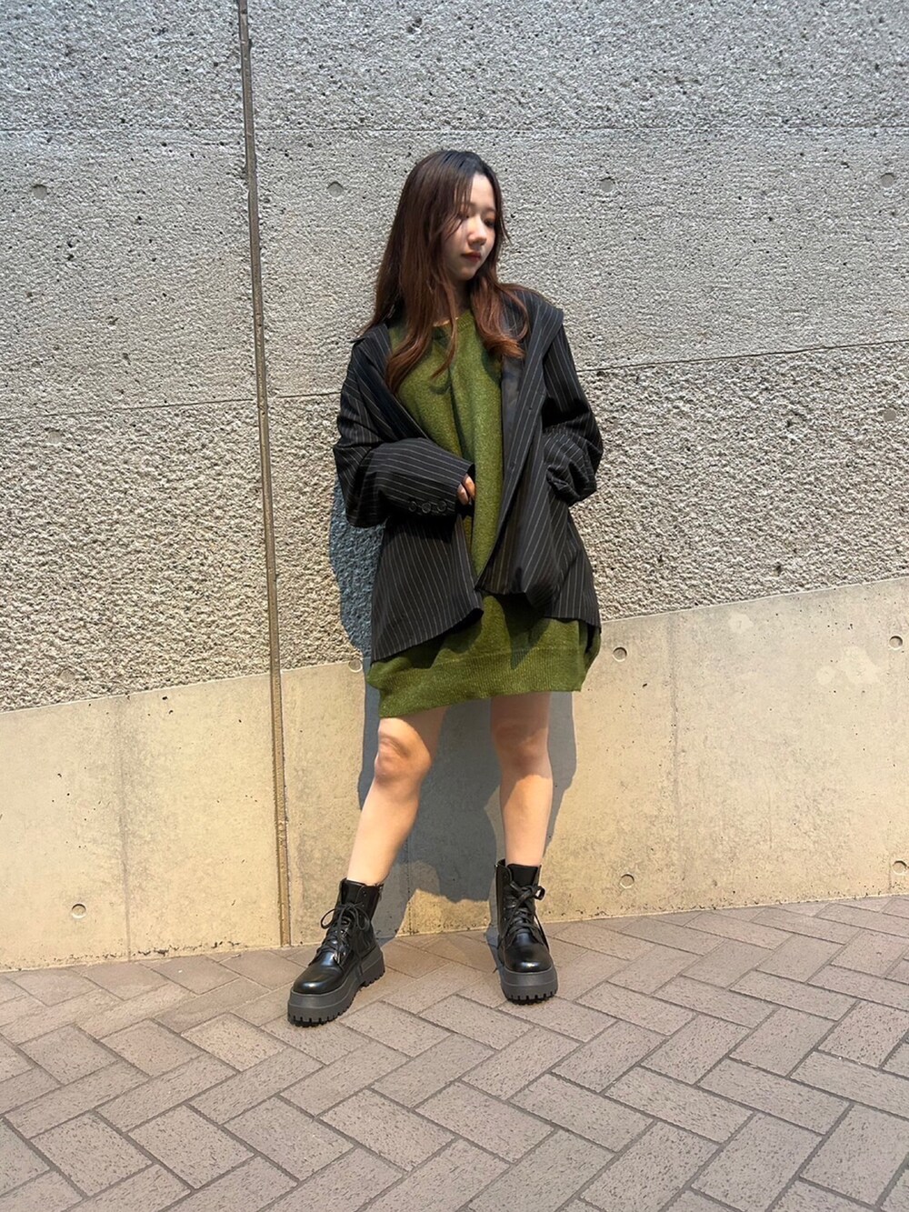 グリーン系のニット/セーター、グレー系のテーラードジャケットを着用したレディースの秋コーディネートの3枚目の写真