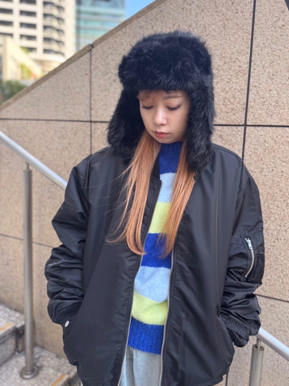 ブラック系のMA-1、ブルー系のニット/セーター、ブルー系のデニムパンツを着用したレディースの冬コーディネートの2枚目の写真