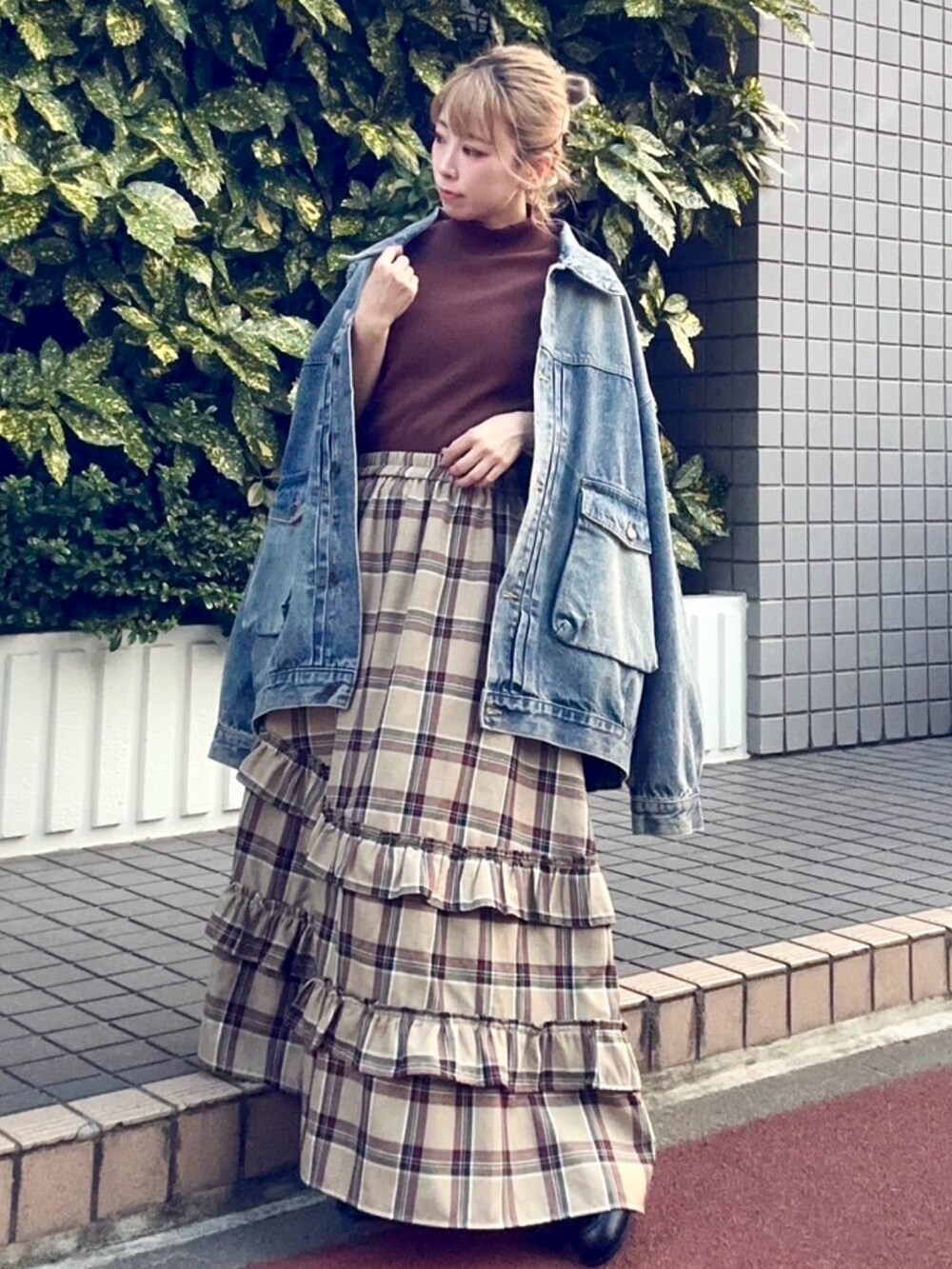 ベージュ系のスカート、ブルー系のデニムジャケット、ブラウン系のTシャツ/カットソーを着用したレディースの秋コーディネートの2枚目の写真