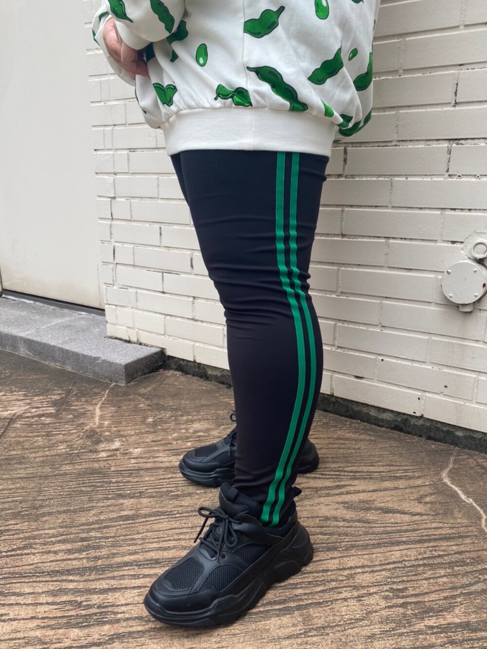 ブラック系のスニーカー、グリーン系のスウェット、グリーン系のレギンス/スパッツを着用したレディースの夏コーディネートの3枚目の写真