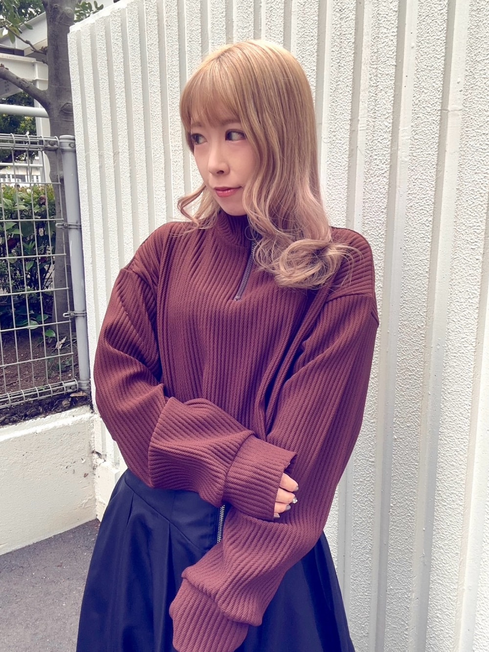 ブラック系のスカート、ブラウン系のスウェットを着用したレディースの秋コーディネートの2枚目の写真