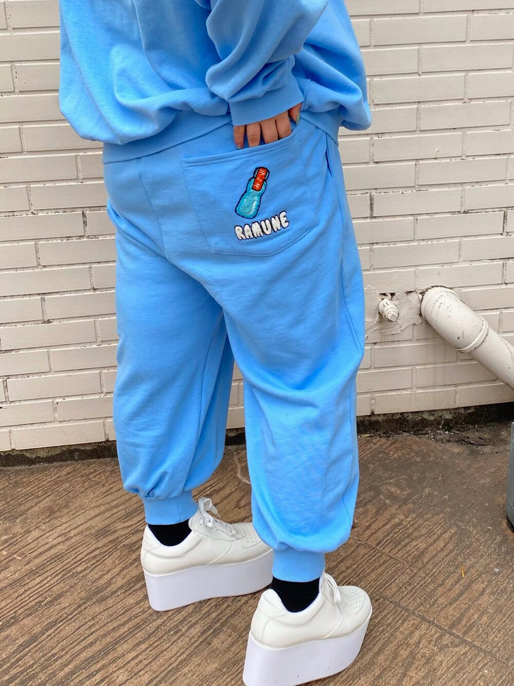 ブルー系のスウェット、ブルー系のスウェットパンツ、ホワイト系のスニーカーを着用したレディースの冬コーディネートの3枚目の写真