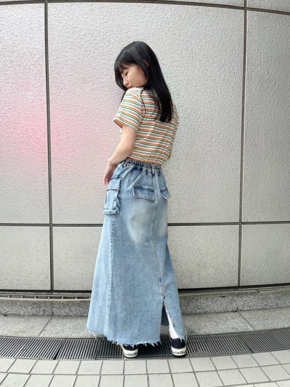 オレンジ系のTシャツ/カットソー、ブルー系のデニムスカートを着用したレディースの春コーディネートの2枚目の写真