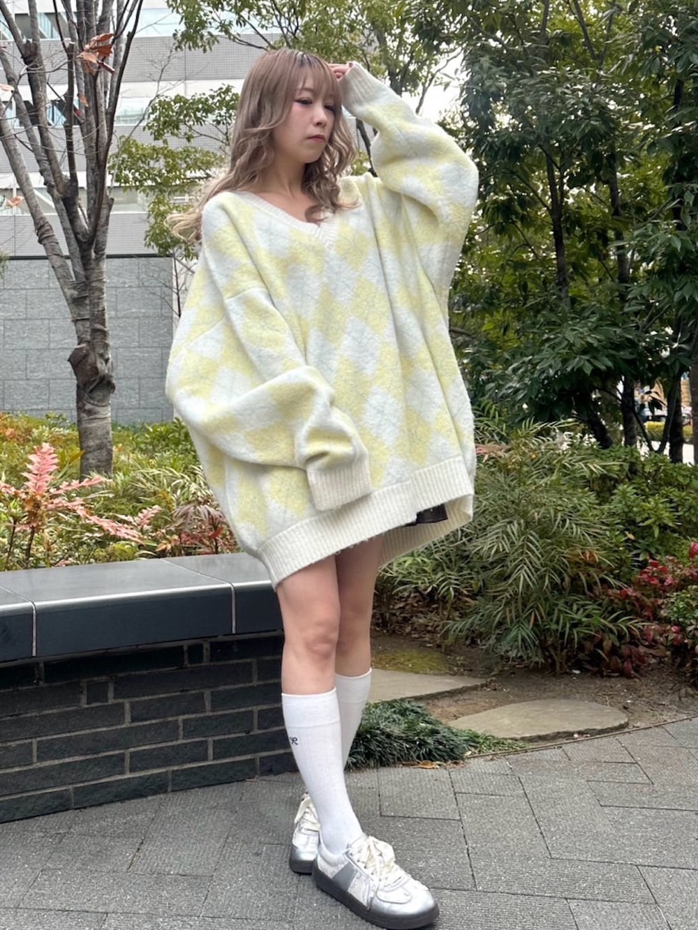 イエロー系のニット/セーターを着用したレディースの冬コーディネートの2枚目の写真