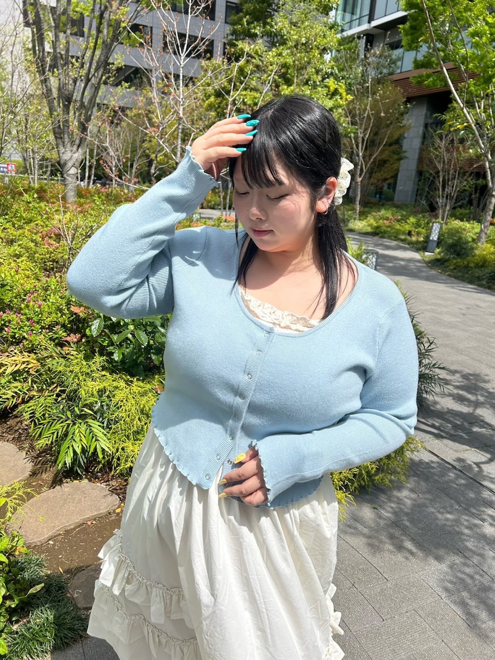 ホワイト系のスカート、ブルー系のカーディガン/ボレロを着用したレディースの春コーディネートの3枚目の写真