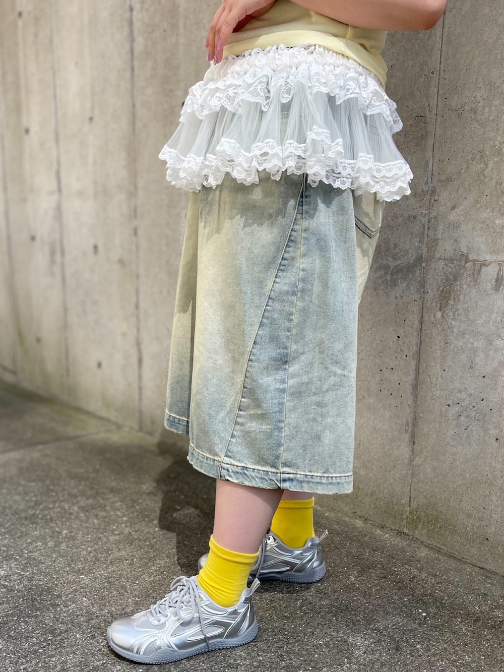 ブルー系のデニムパンツ、ホワイト系のスカート、イエロー系のTシャツ/カットソーを着用したレディースの夏コーディネートの8枚目の写真