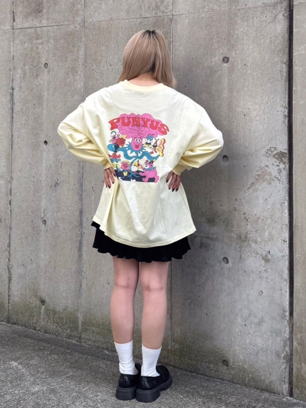 イエロー系のTシャツ/カットソー、ブラック系のスカートを着用したレディースの冬コーディネートの3枚目の写真