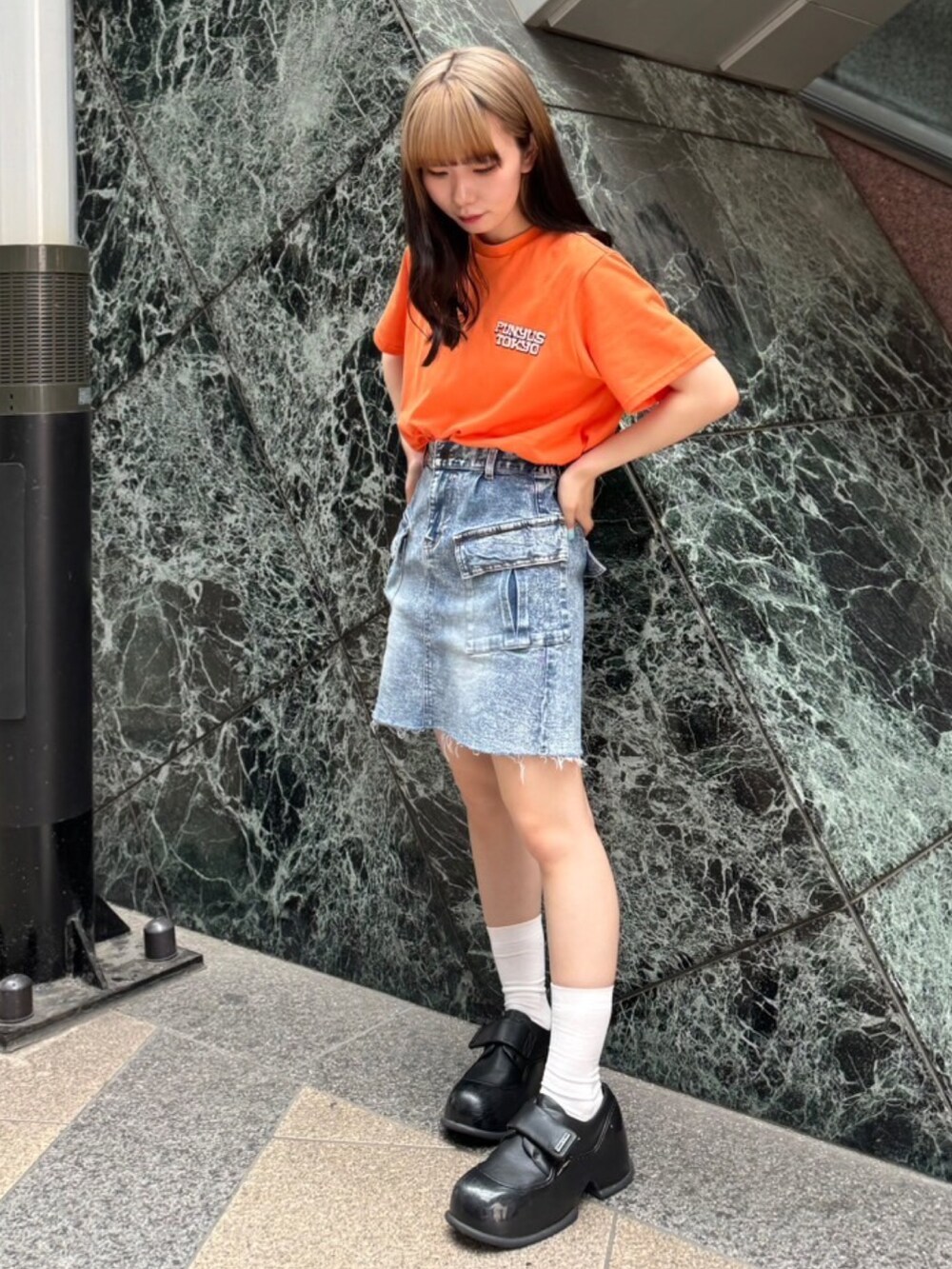 オレンジ系のTシャツ/カットソー、ブルー系のデニムスカートを着用したレディースの夏コーディネートの3枚目の写真