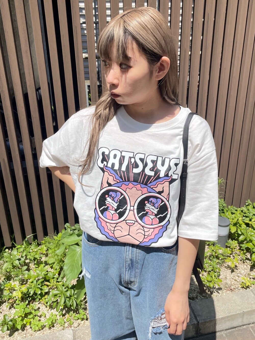ブルー系のデニムパンツ、グレー系のTシャツ/カットソー、ブラック系のショルダーバッグを着用したレディースの夏コーディネートの3枚目の写真