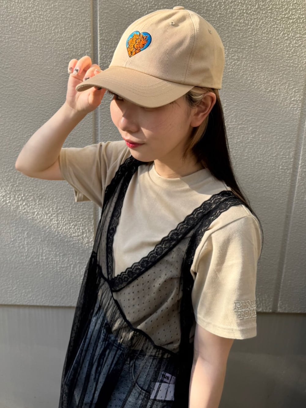 ブルー系のデニムパンツ、ブラック系のワンピース、ベージュ系のTシャツ/カットソーを着用したレディースの夏コーディネートの3枚目の写真