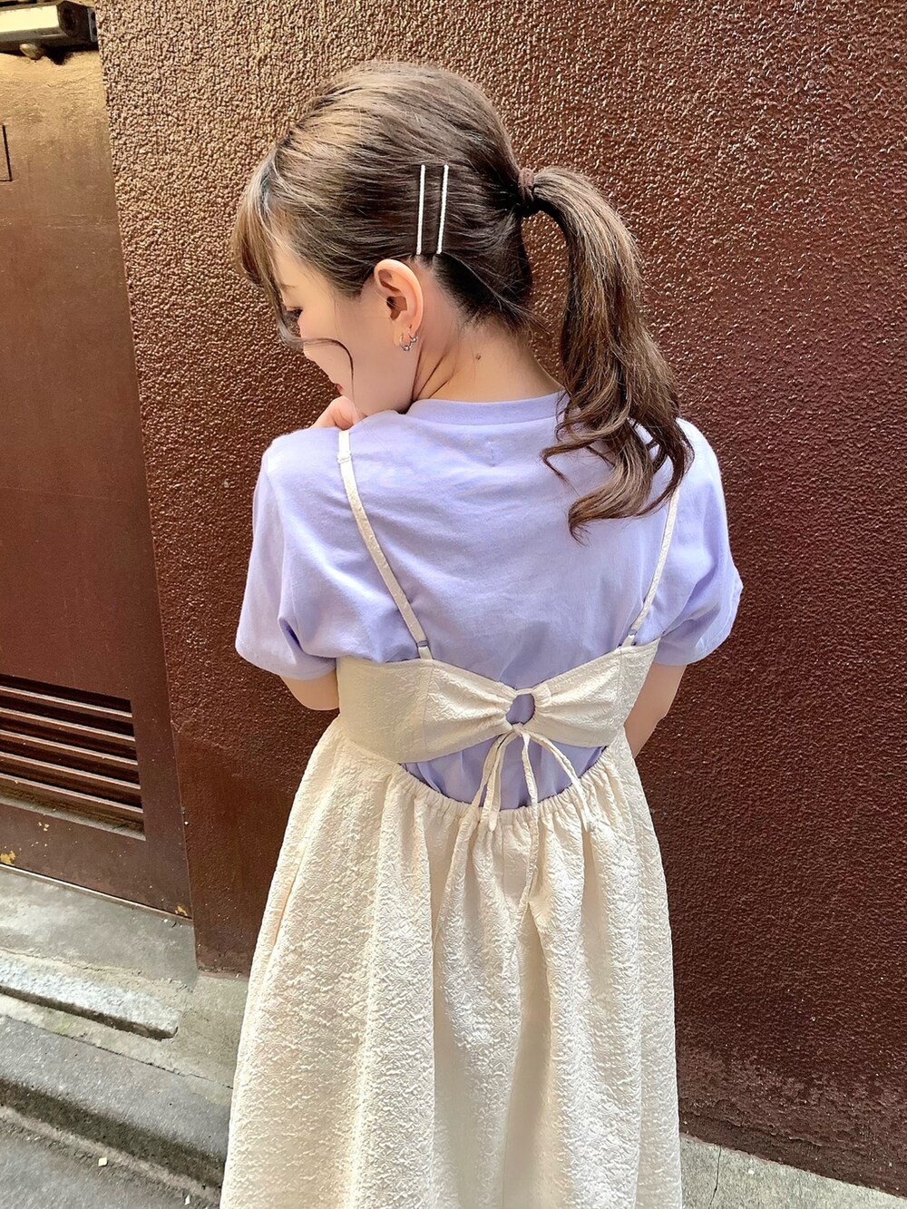 ホワイト系のワンピース、パープル系のTシャツ/カットソーを着用したレディースの春コーディネートの3枚目の写真