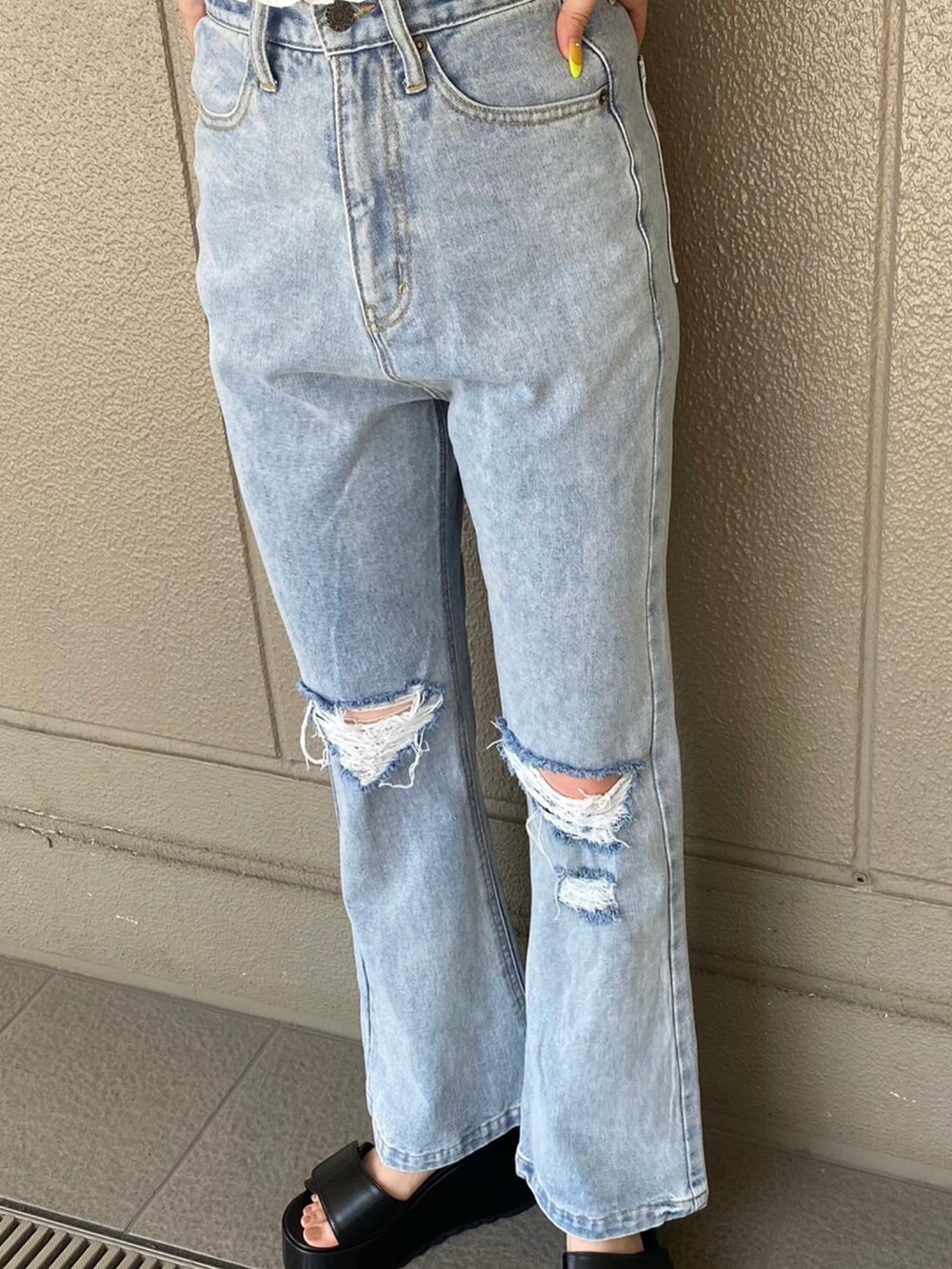 ブルー系のデニムパンツ、ブラック系のサンダル、ホワイト系のシャツ/ブラウスを着用したレディースの夏コーディネートの3枚目の写真