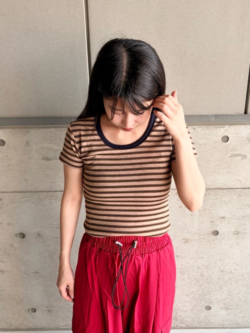 レッド系のカーゴパンツ、ブラウン系のTシャツ/カットソーを着用したレディースの夏コーディネートの5枚目の写真