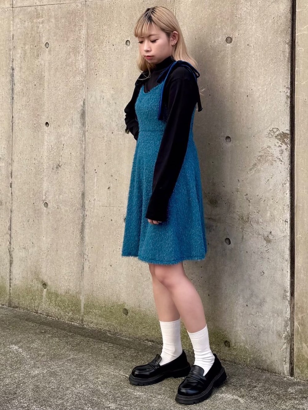 ブルー系のワンピース、ブラック系のニット/セーターを着用したレディースの冬コーディネートの2枚目の写真