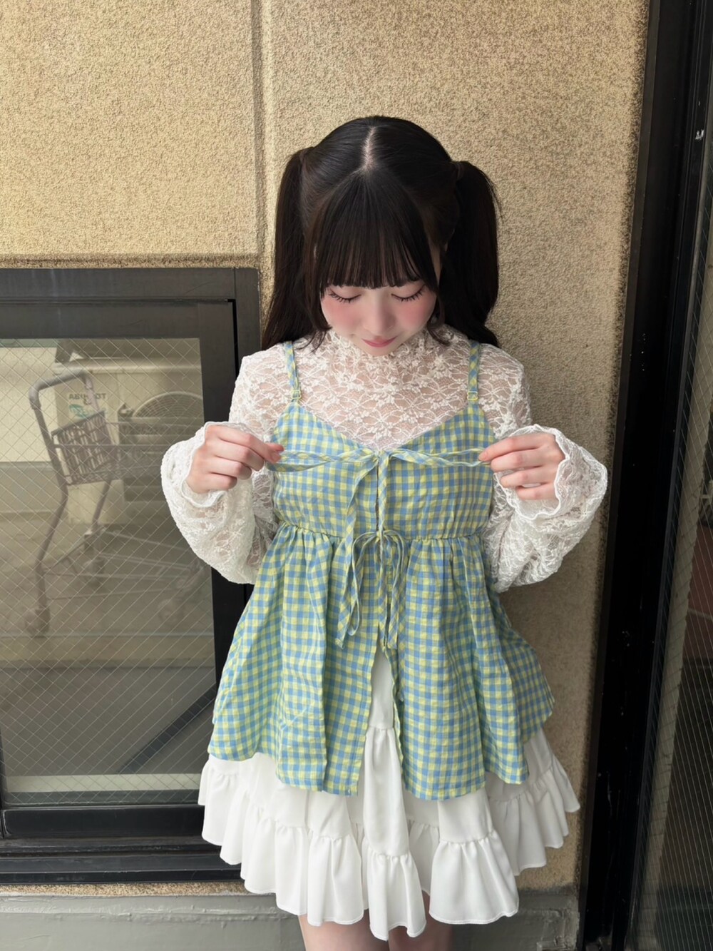 ホワイト系のスカート、イエロー系のキャミソール、ホワイト系のTシャツ/カットソーを着用したレディースの夏コーディネートの2枚目の写真