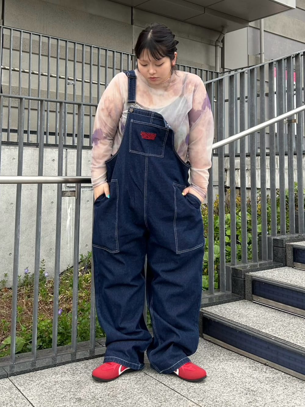 ブルー系のサロペット/オーバーオール、パープル系のTシャツ/カットソーを着用したレディースの春コーディネートの2枚目の写真