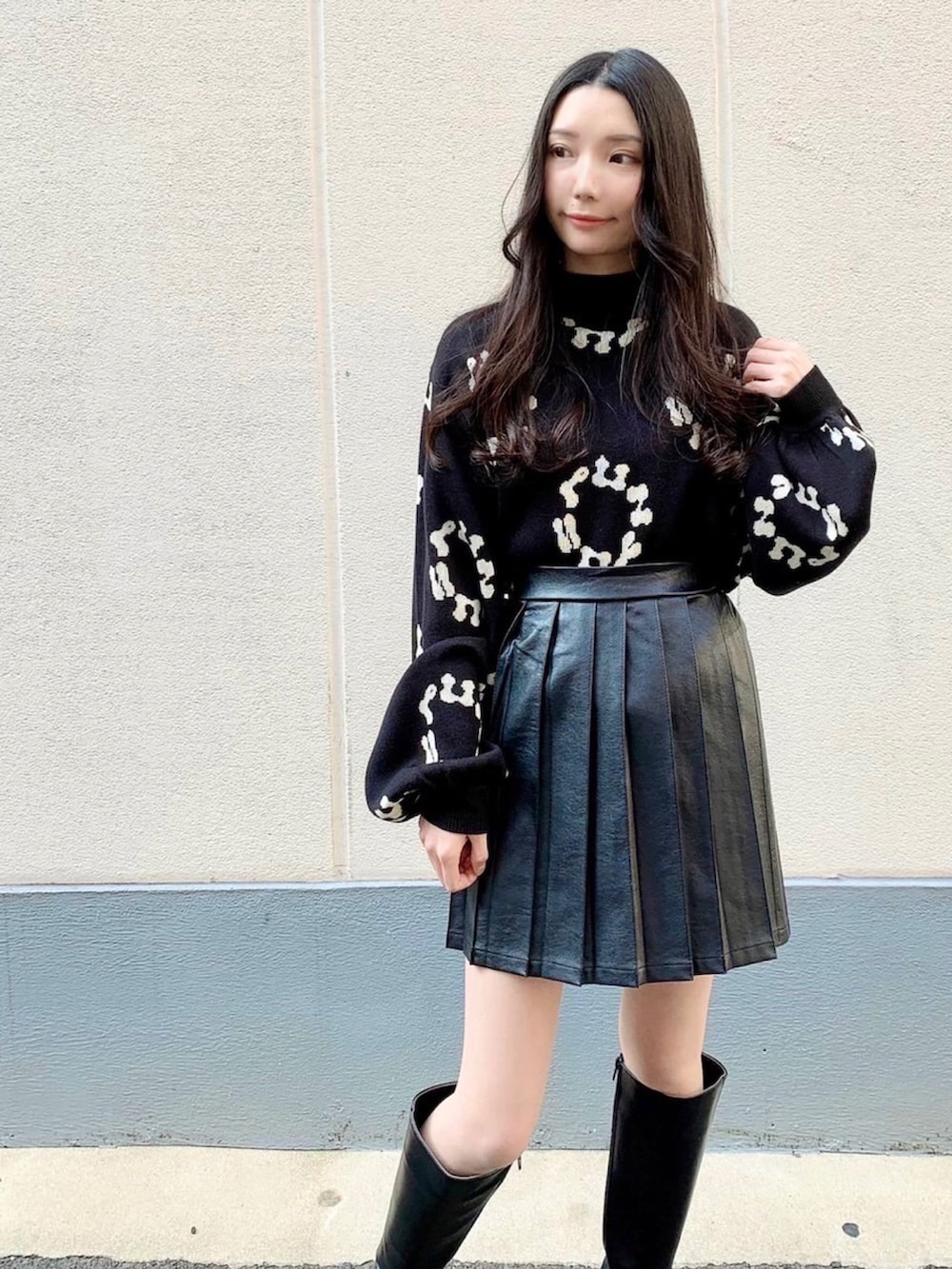 ブラック系のニット/セーター、ブラック系のスカートを着用したレディースの冬コーディネートの2枚目の写真