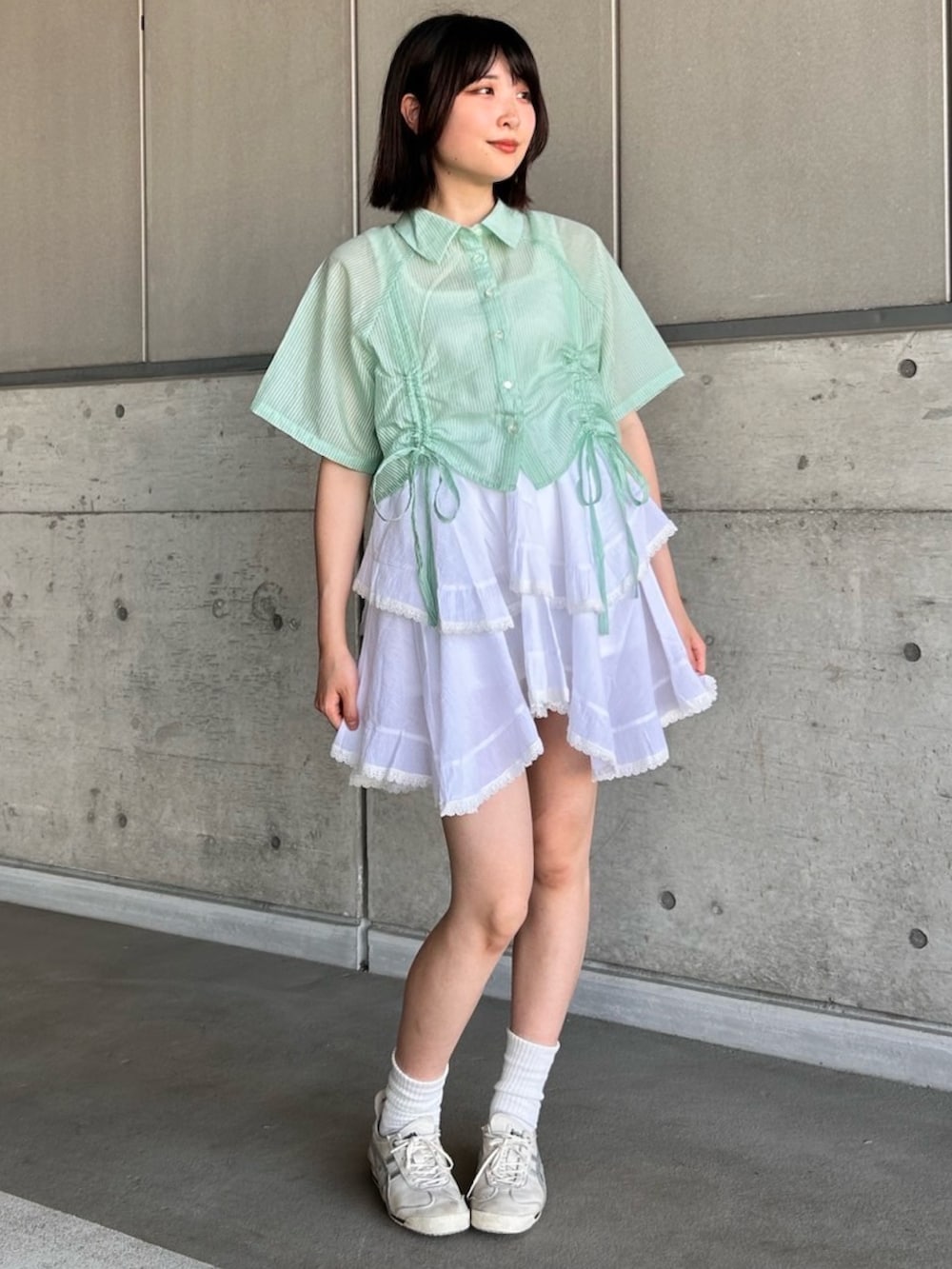 ホワイト系のスカート、グリーン系のシャツ/ブラウスを着用したレディースの夏コーディネートの3枚目の写真