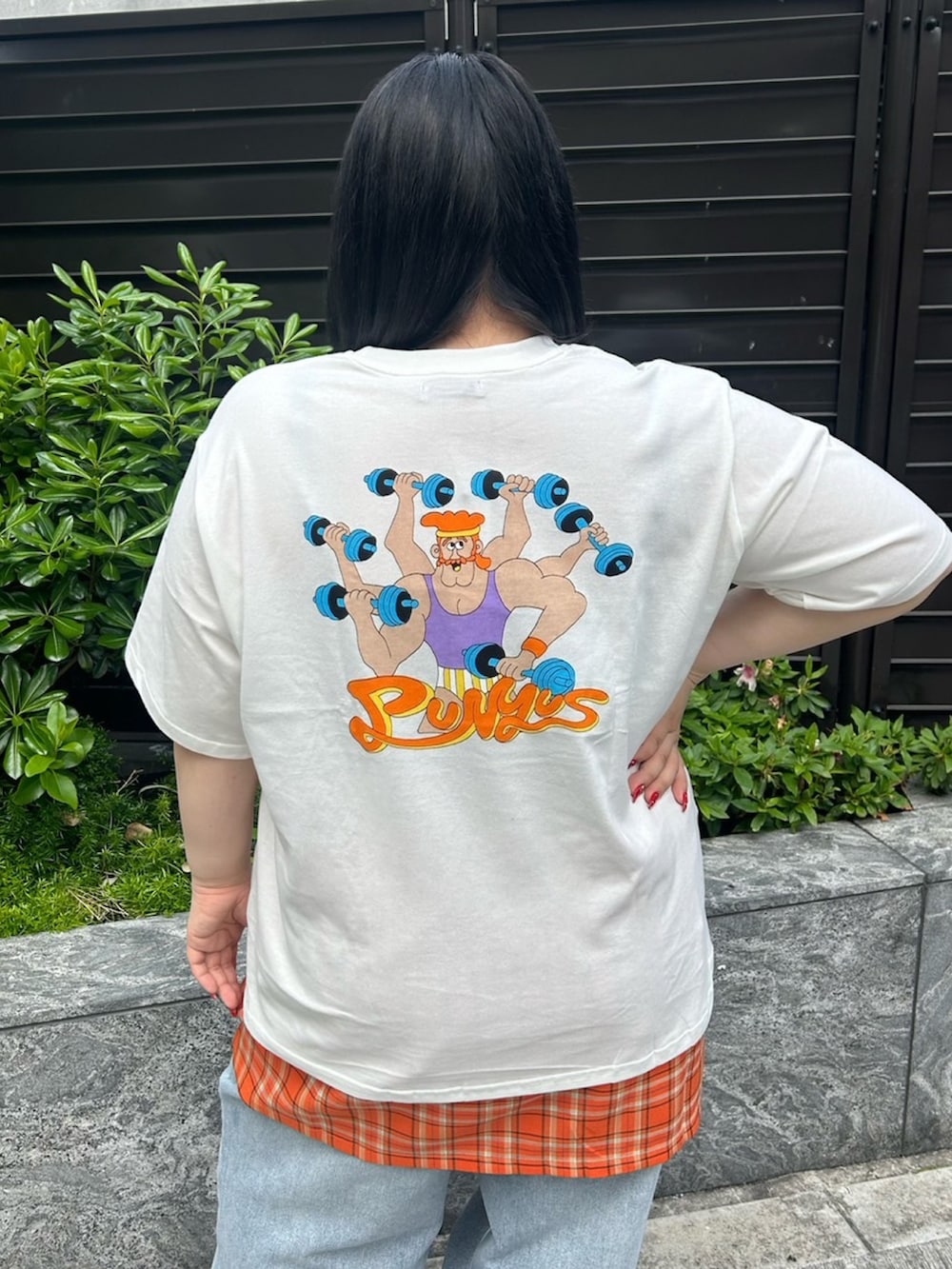 ブルー系のデニムパンツ、オレンジ系のスカート、ホワイト系のTシャツ/カットソーを着用したレディースの春コーディネートの5枚目の写真