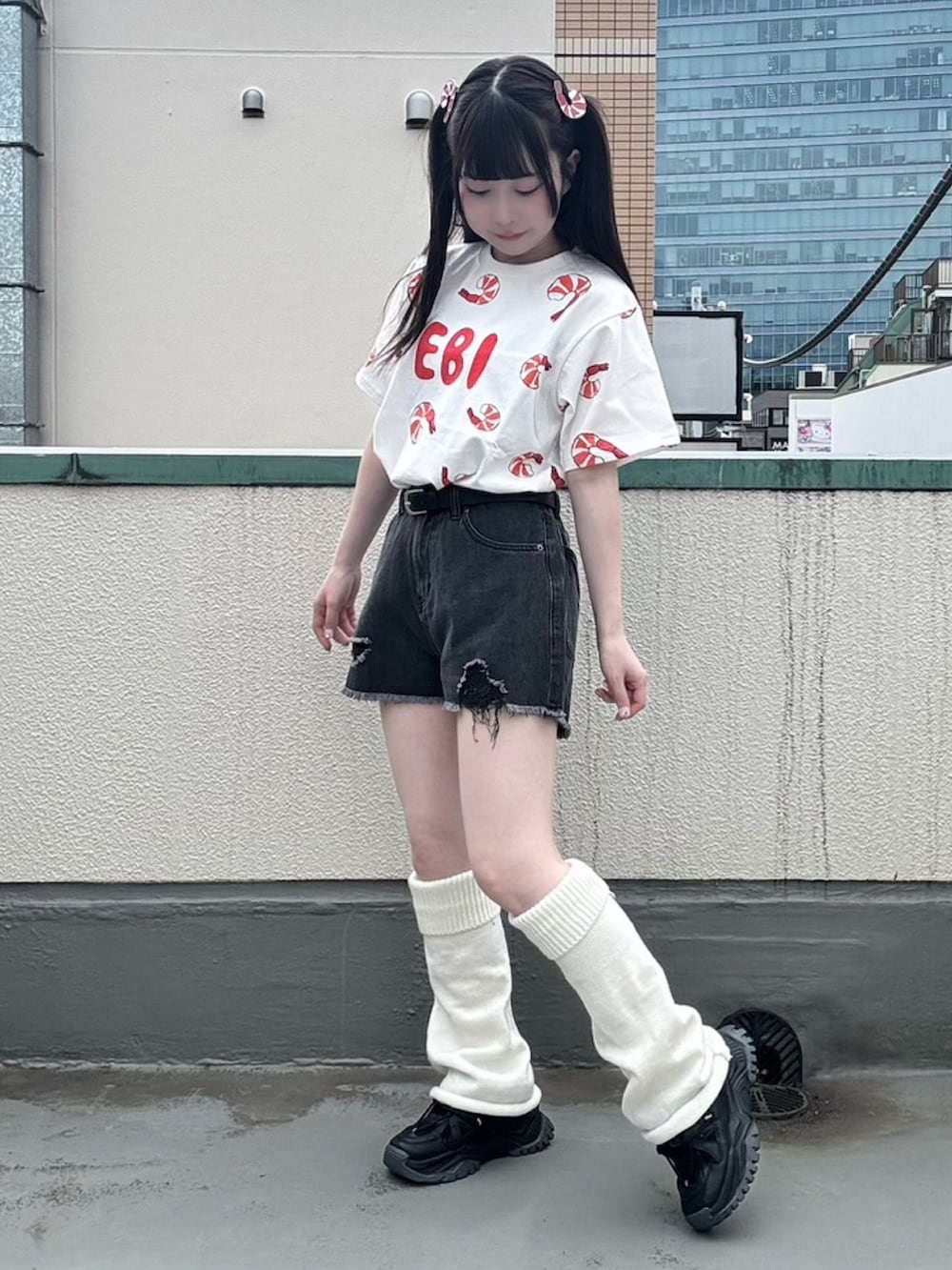 ブラック系のデニムパンツ、レッド系のTシャツ/カットソー、ブラック系のベルトを着用したレディースの春コーディネートの2枚目の写真