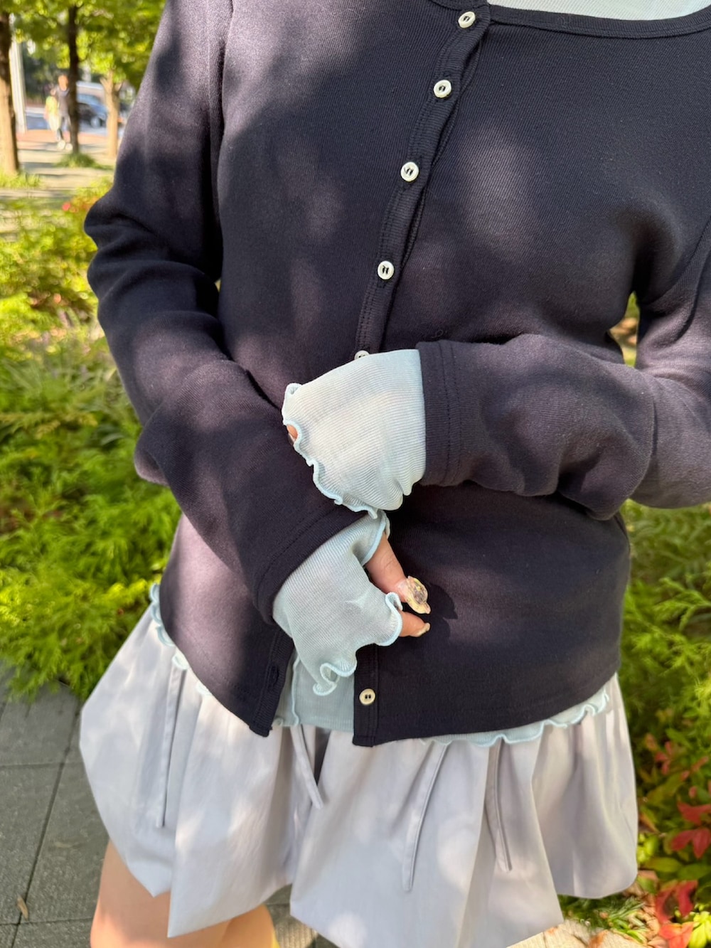 グレー系のスカート、ブルー系のTシャツ/カットソー、ブルー系のカーディガン/ボレロを着用したレディースの秋コーディネートの6枚目の写真