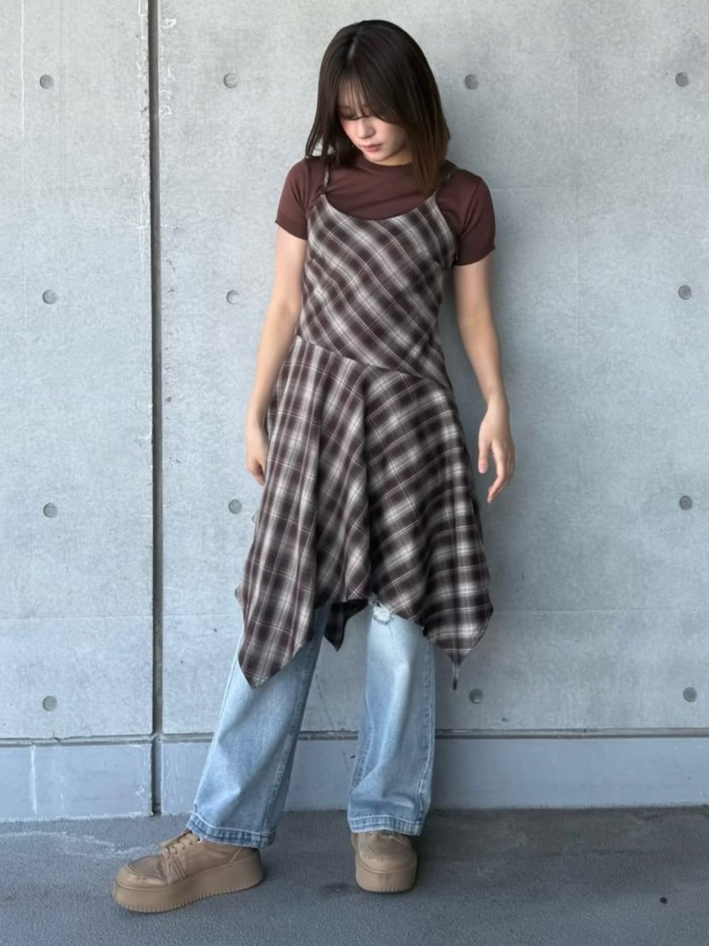 ブルー系のデニムパンツ、ブラウン系のワンピース、ブラウン系のニット/セーターを着用したレディースの春コーディネートの2枚目の写真