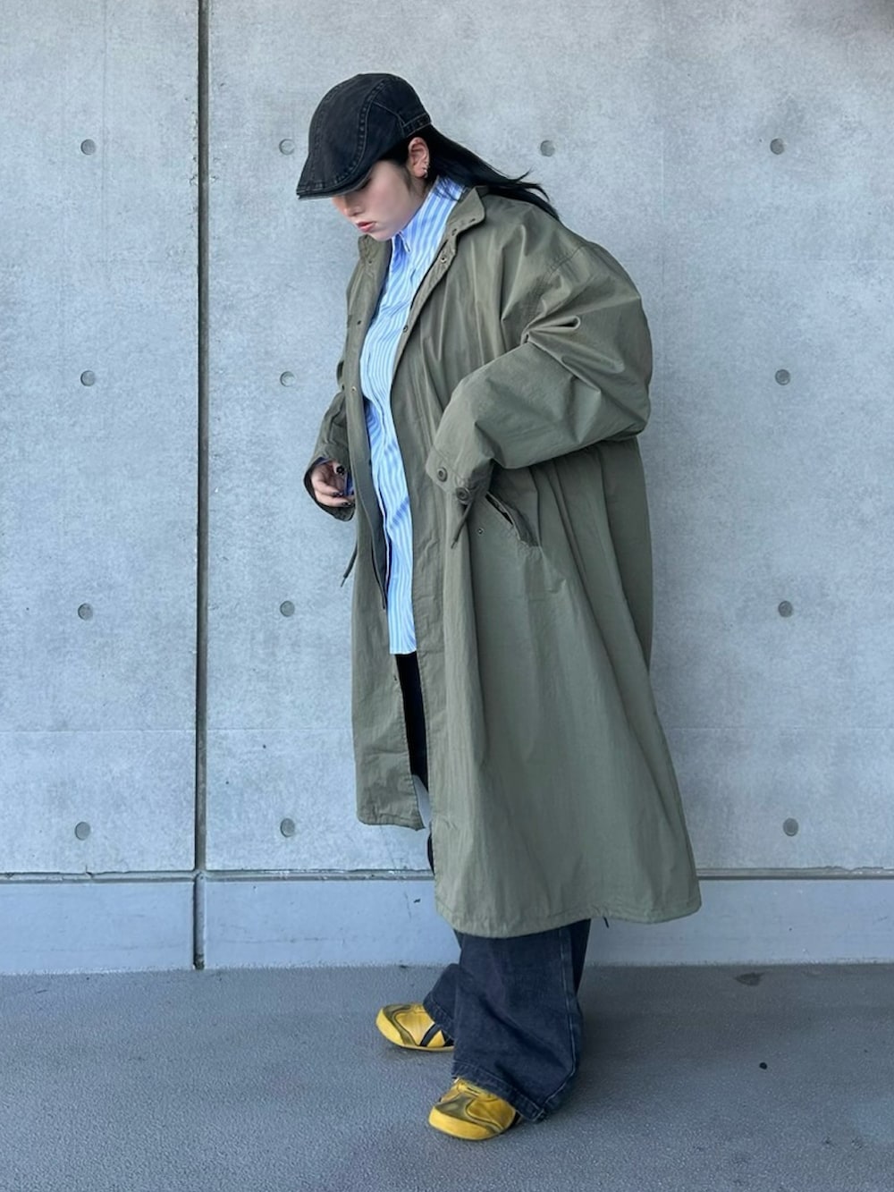 グリーン系のモッズコート、ブルー系のシャツ/ブラウス、ブラック系のデニムパンツを着用したレディースの春コーディネートの3枚目の写真