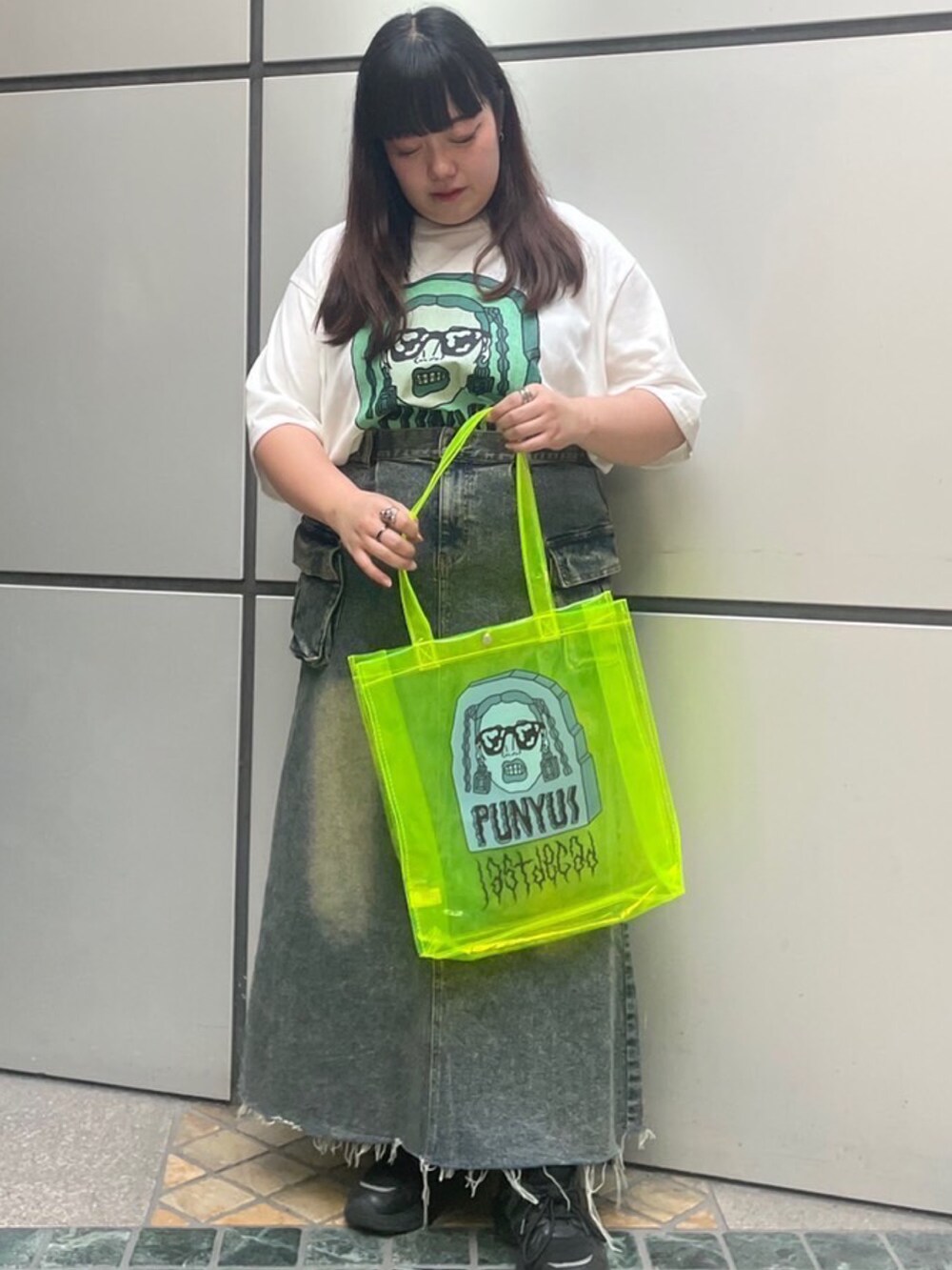 ホワイト系のTシャツ/カットソー、ブルー系のデニムスカート、イエロー系のトートバッグを着用したレディースの夏コーディネートの3枚目の写真