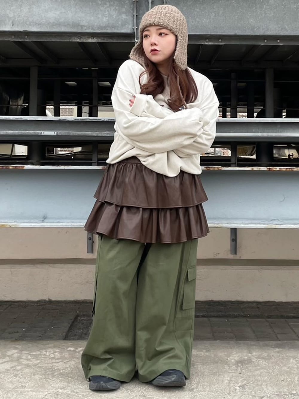 ベージュ系のスウェット、ブラウン系のスカート、グリーン系のカーゴパンツを着用したレディースの冬コーディネートの2枚目の写真