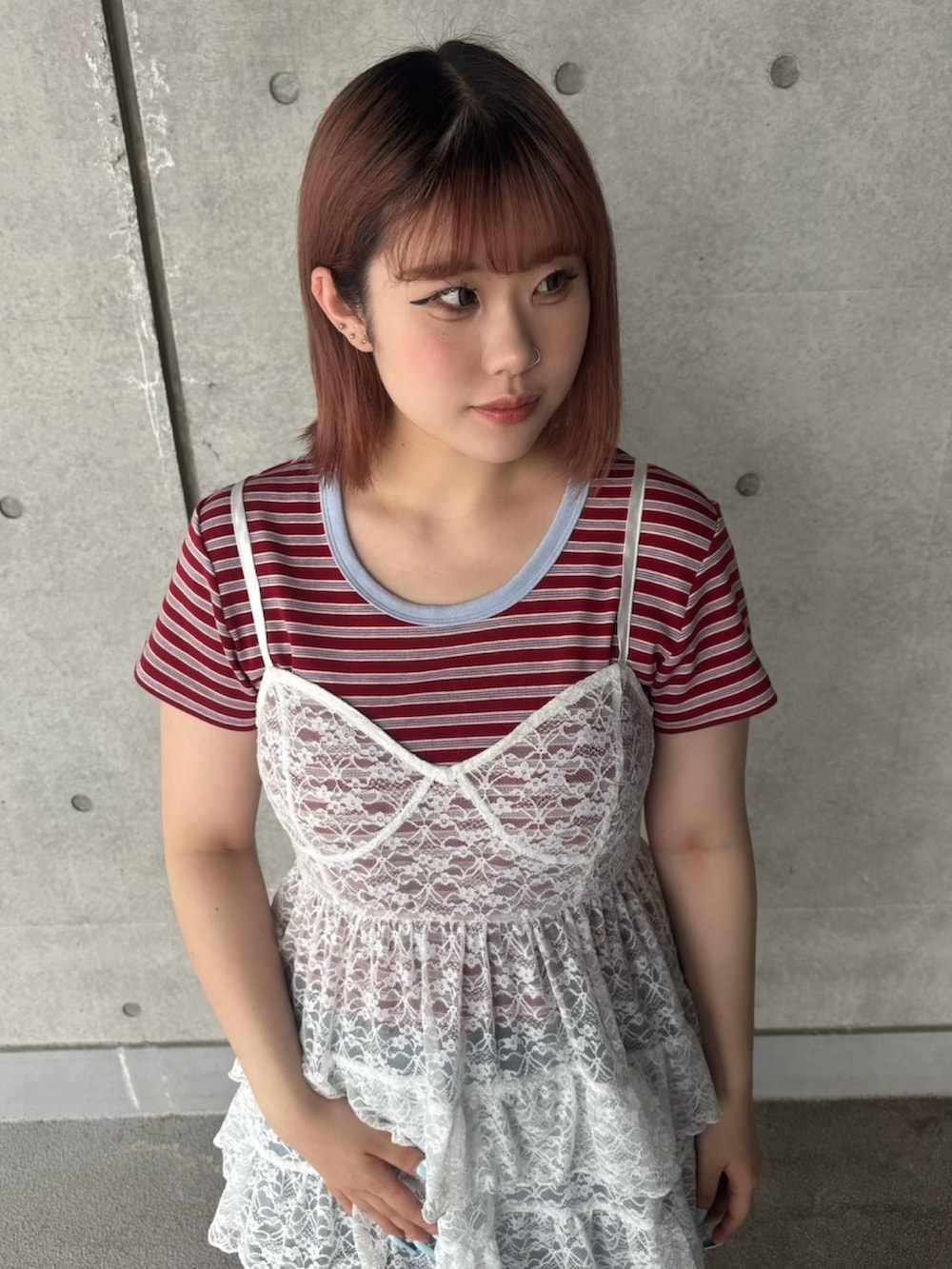 ブルー系のデニムスカート、レッド系のTシャツ/カットソー、ホワイト系のワンピースを着用したレディースの春コーディネートの3枚目の写真