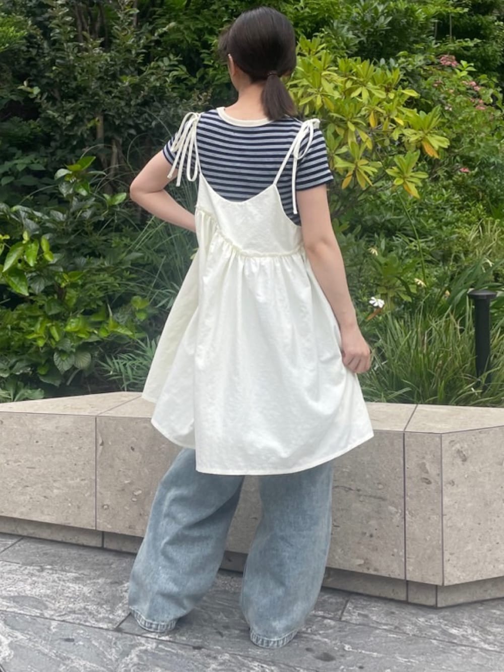 ブルー系のデニムパンツ、ホワイト系のワンピース、ブルー系のTシャツ/カットソーを着用したレディースの夏コーディネートの5枚目の写真