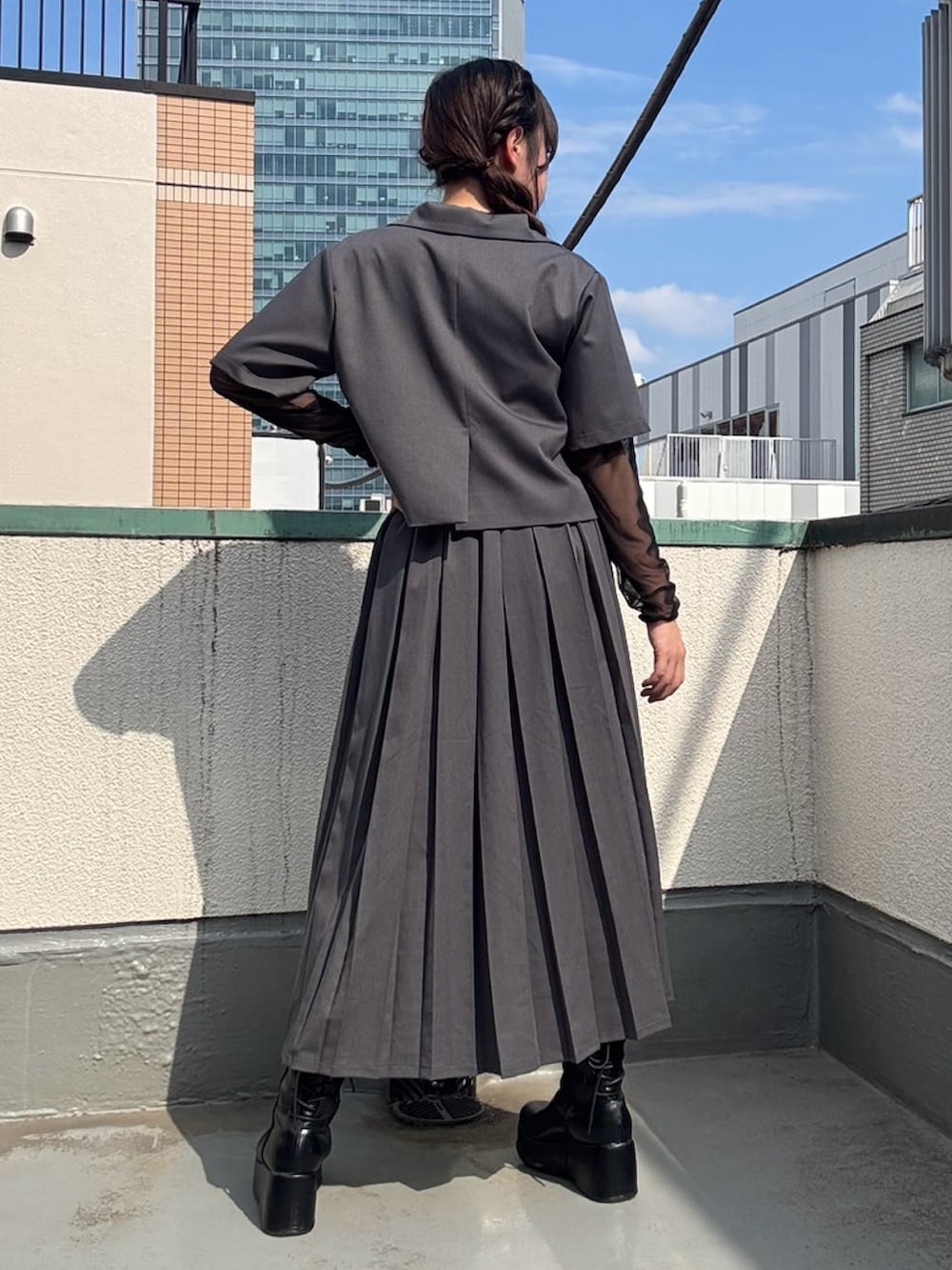 グレー系のスカート、グレー系のテーラードジャケット、ブラック系のTシャツ/カットソーを着用したレディースの春コーディネートの4枚目の写真