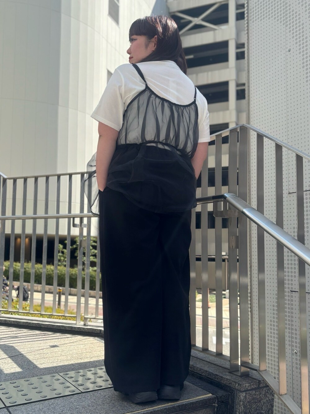 ブラック系のその他パンツ、ブラック系のキャミソール、ホワイト系のTシャツ/カットソーを着用したレディースの春コーディネートの2枚目の写真