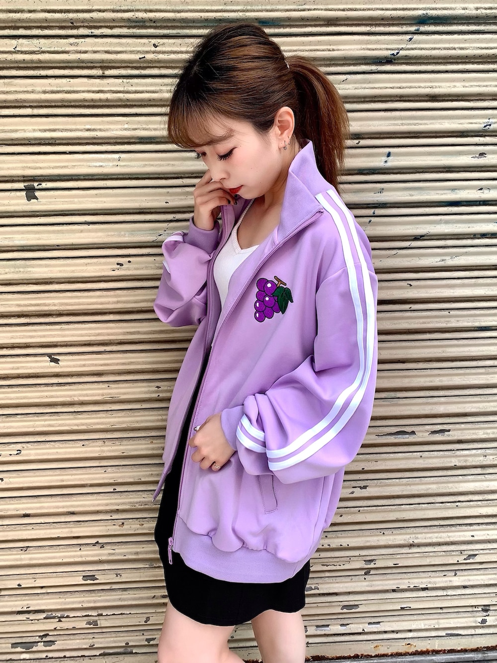 ホワイト系のタンクトップ、パープル系のジャージ、ブラック系のスカートを着用したレディースの夏コーディネートの3枚目の写真