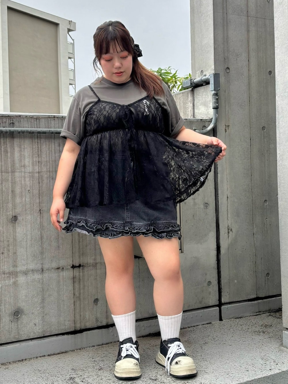 ブラック系のチュニック、ブラック系のデニムスカート、ブラック系のTシャツ/カットソーを着用したレディースの夏コーディネートの4枚目の写真