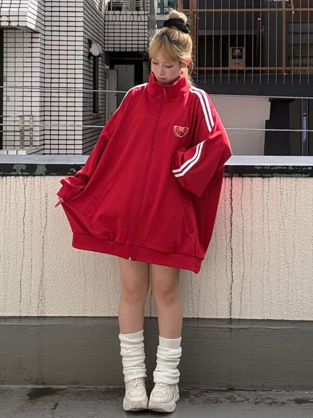 レッド系のジャージを着用したレディースの秋コーディネートの2枚目の写真