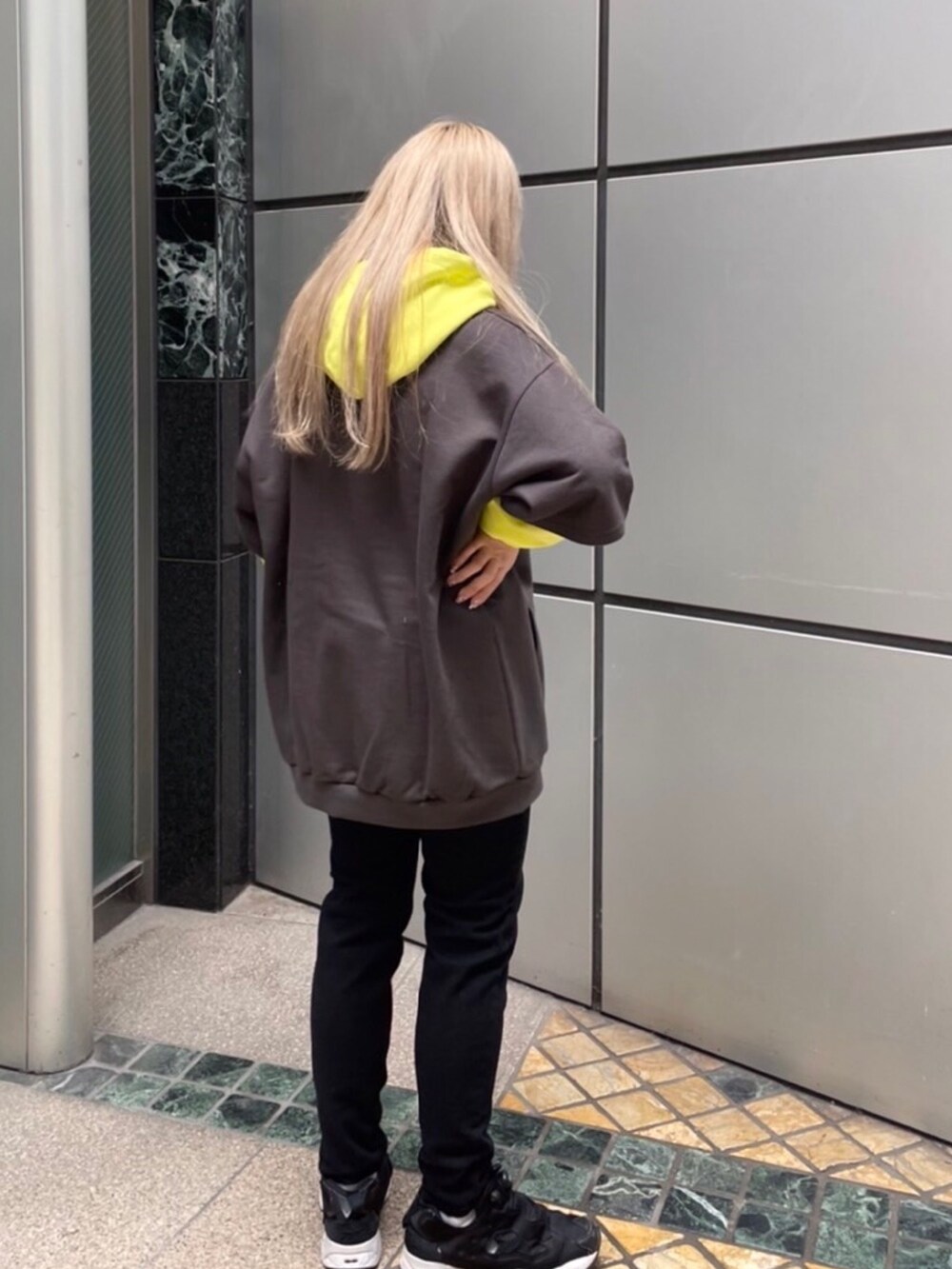 ブラック系のパーカー、ブラック系のデニムパンツを着用したレディースの春コーディネートの2枚目の写真