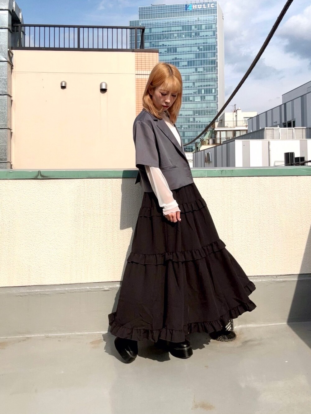 グレー系のテーラードジャケット、グレー系のスカート、ホワイト系のシャツ/ブラウスを着用したレディースの夏コーディネートの4枚目の写真