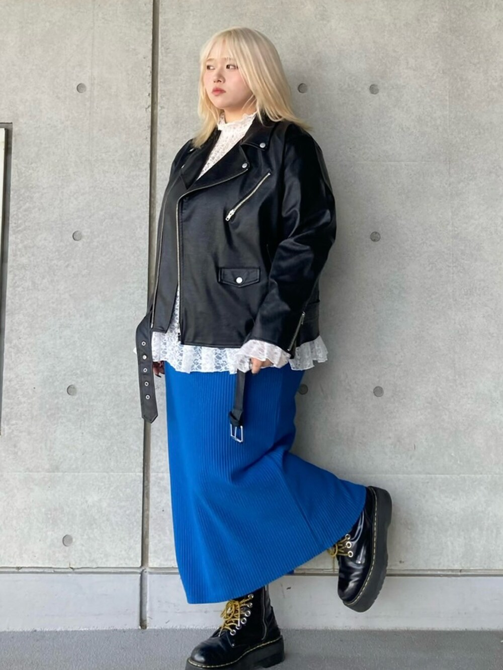 ブラック系のライダースジャケット、ホワイト系のTシャツ/カットソー、ブルー系のスカートを着用したレディースの秋コーディネートの2枚目の写真